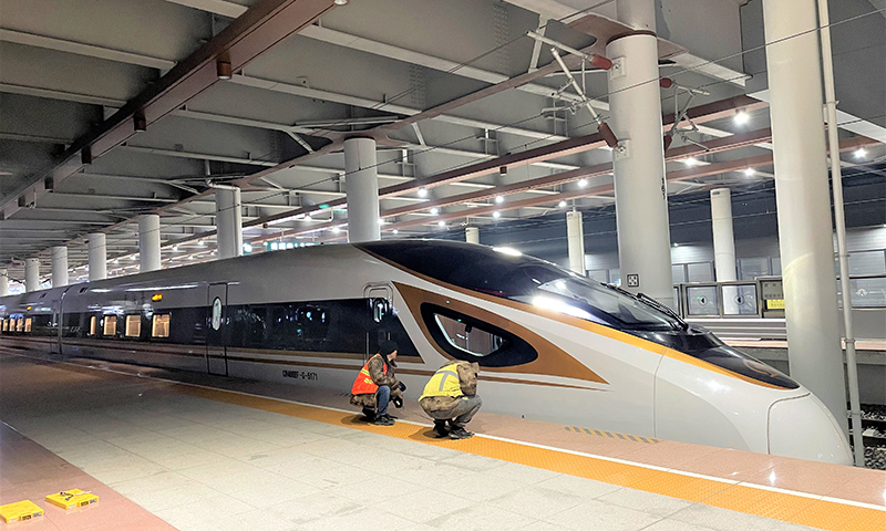 图为中铁六局电务公司建设者确认动车停车位置是否准确。