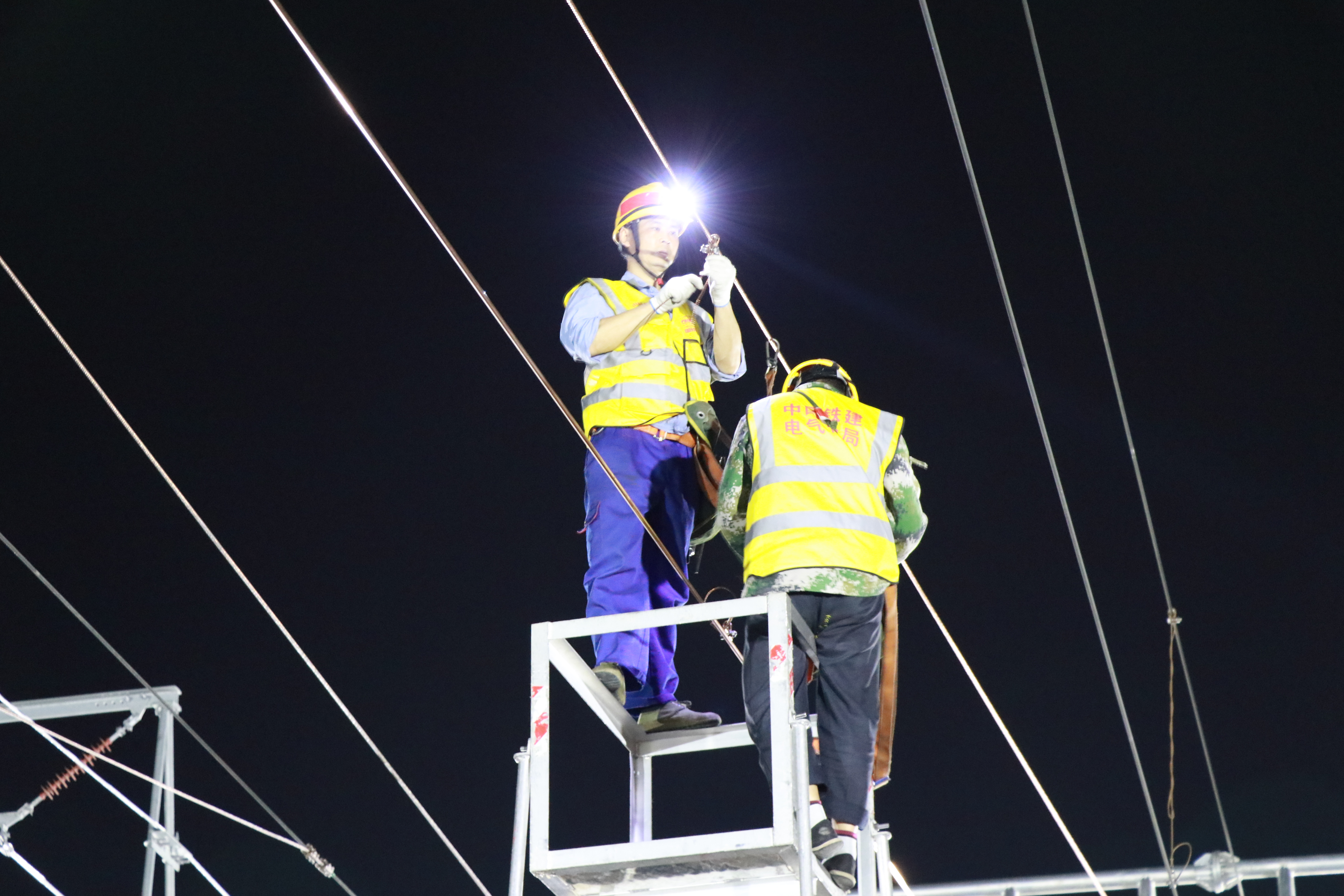 南京南站改“四电”工程影响范围广，白天高铁不停运、列车不降速，要求夜间“天窗”施工组织一气呵成，该集团以“四电”集成商优势，组织260多名专业技术人员，连续近3个月、80余个高铁夜间天窗，实现南京南站场改造告捷，为国内高铁枢纽站场改造提炼出一份实战式“四电”施工作业指导书，给日后同类型高铁枢纽改造提供重要参考价值。图为建设者夜间调接触网吊弦。