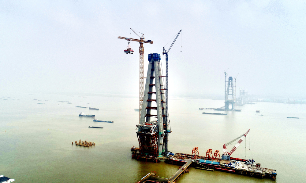 近日，随着280吨重的底节钢塔稳稳放置在250米高的中塔柱合龙段上，中国中铁旗下中铁大桥院设计、中铁大桥局承建、中铁工业参建的常泰长江大桥主航道桥6号主塔转入上塔柱施工阶段。常泰长江大桥主航道桥主跨达1176米，是世界最大跨度公铁两用斜拉桥，6号主塔设计高度352米，是世界在建最高桥塔。