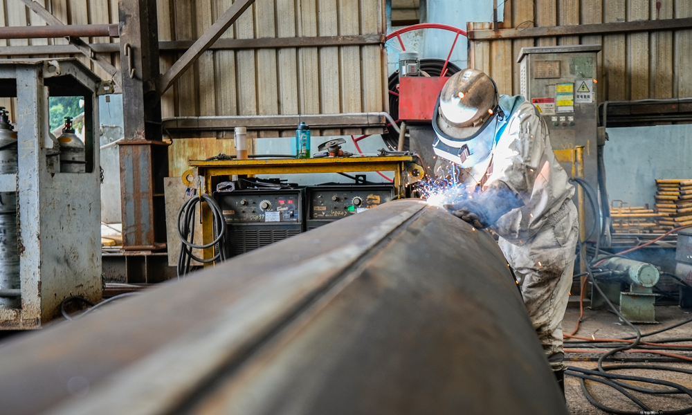 乐东10-1项目计划新建一座无人井口平台，其导管架为四腿八裙装，重约3250吨，配套钢桩约4050吨，用于支撑重量1900余吨的上部组块。导管架采用卧式建造、拖拉装船、吊装下水、充水扶正的施工方案。图为工作人员正在对纵焊缝进行焊接作业。