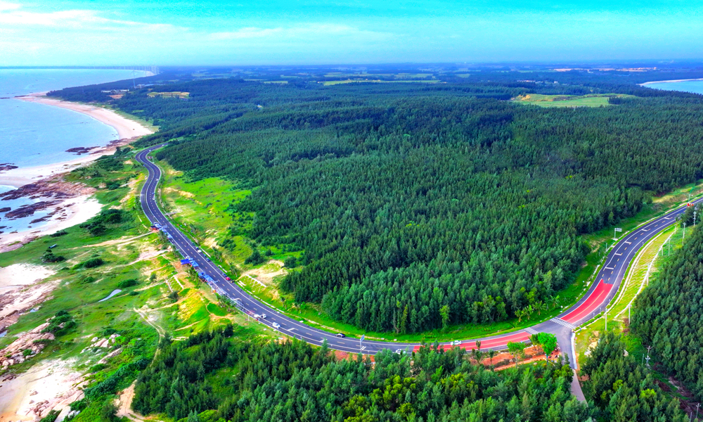 海南环岛旅游公路主线总里程为988公里，其中新建改建段453公里（连接线、支线、鱼骨线等新建改建90公里）、利用段535公里，贯穿海口、文昌、琼海等沿海12个市县。中铁二局、中铁北京局承建海南环岛旅游公路文昌段、昌化段、珠碧江段工程，地跨文昌、琼海、东方、昌江、儋州五地，路线总长度约218公里；中铁八局承建公路沿线附属配套工程，负责公路沿线8处养护工区房建施工。该项目具有标段线路长、施工组织难度大、沿海受汛期台风影响大、海域环保要求高等特点。图为海南环岛旅游公路木兰湾。