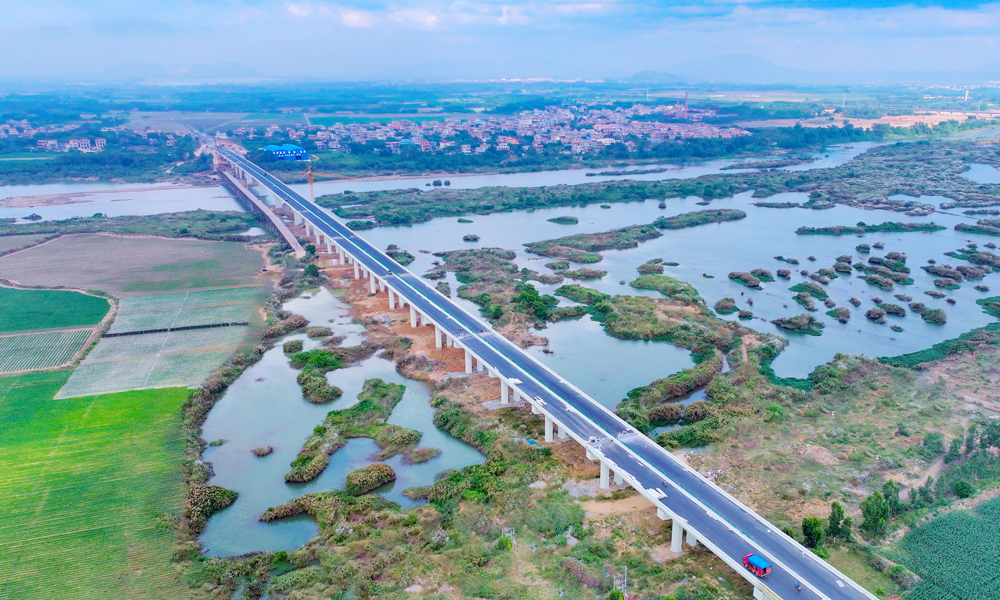 针对旅游公路建设点多线长、作业面广、影响因素多等困难，项目团队充分利用“BIM智慧建造+无人机航测技术”，将数字化设计和精细化相结合，缩短了施工工期，提高了施工质量；采用全自动滑模机进行混凝土水沟施工，成品外观平顺，强度、结构尺寸等均满足设计要求，降低了施工成本，减少了环境污染，实现了智慧建造与绿色工地的高度统一。图为海南环岛旅游公路昌化江大桥。