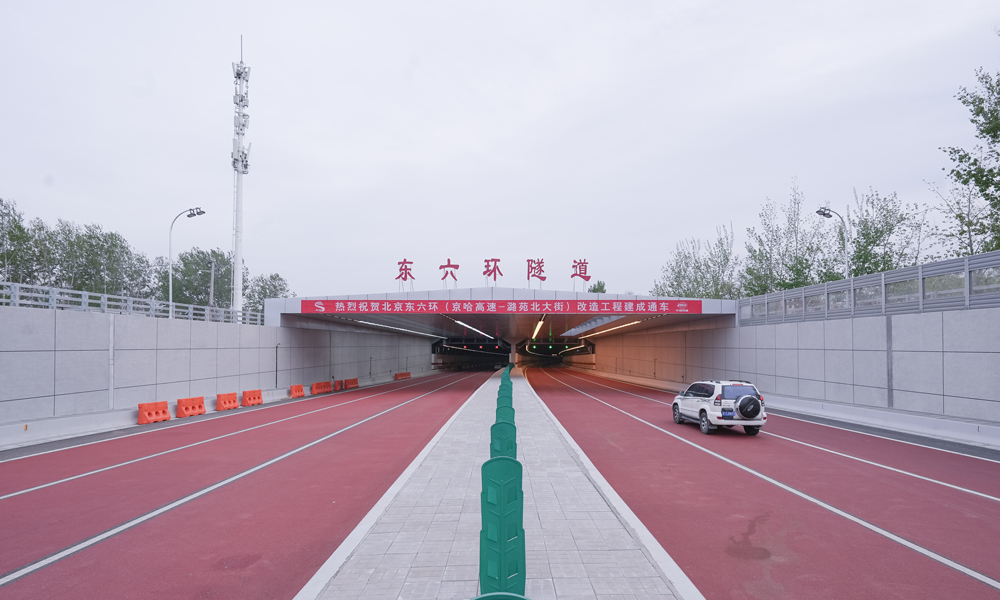 东六环改造工程是落实《北京城市总体规划》和《北京城市副中心控制性详细规划》的市重点工程，位于北京市通州区城市副中心，南起京哈高速、北至潞苑北大街，线路全长约16.3公里，其中约7.4公里长的盾构隧道是全线控制性工程，也是我国已建成最长盾构高速公路隧道。通过盾构法施工让六环路入地，既能不破坏地面河流、草木、建筑，还能通过地面还绿，“缝合”被割裂的城市空间。图为北京东六环隧道北口。