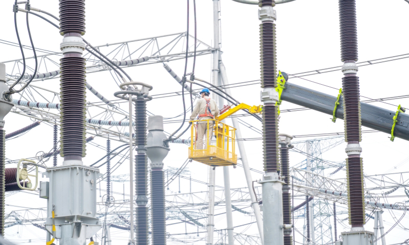 国家电网江苏常州供电公司工作人员在500千伏茅山变7号主变扩建工程现场安装设备。　