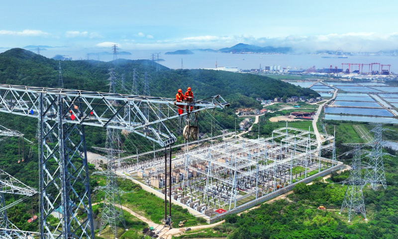 近日，浙江舟山500千伏联网输变电工程迎来首次双线（洛春5495线、洛晓5496线）检修。自2019年投运以来，该工程已累计输电超330亿千瓦时。国网浙江省电力有限公司安排6名检修人员以双线同步走线方式开展检修作业，为浙东电网迎峰度夏奠定坚实基础。图为检修人员对铁塔构件进行检查。