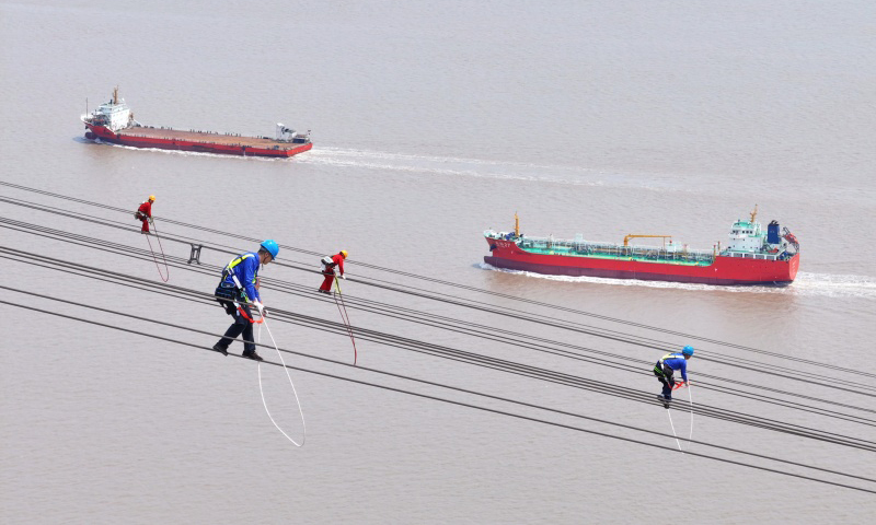 国家电网检修人员在跨海输电导线上开展高空走线作业。