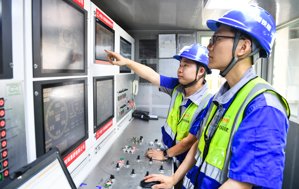 为打造精品隧道工程，项目团队量身打造了“厦金号”超大直径泥水平衡盾构机。该盾构机开挖直径达16.15米，整机长度约165米，总重量约5100吨，是目前福建省最大直径的盾构施工设备。图为工程管理人员操作盾构机开始掘进。