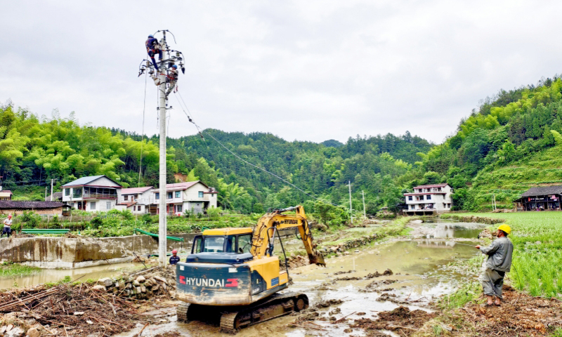 国网湖南邵阳供电公司员工在金屋塘镇抢修因暴雨受损的配电线路。