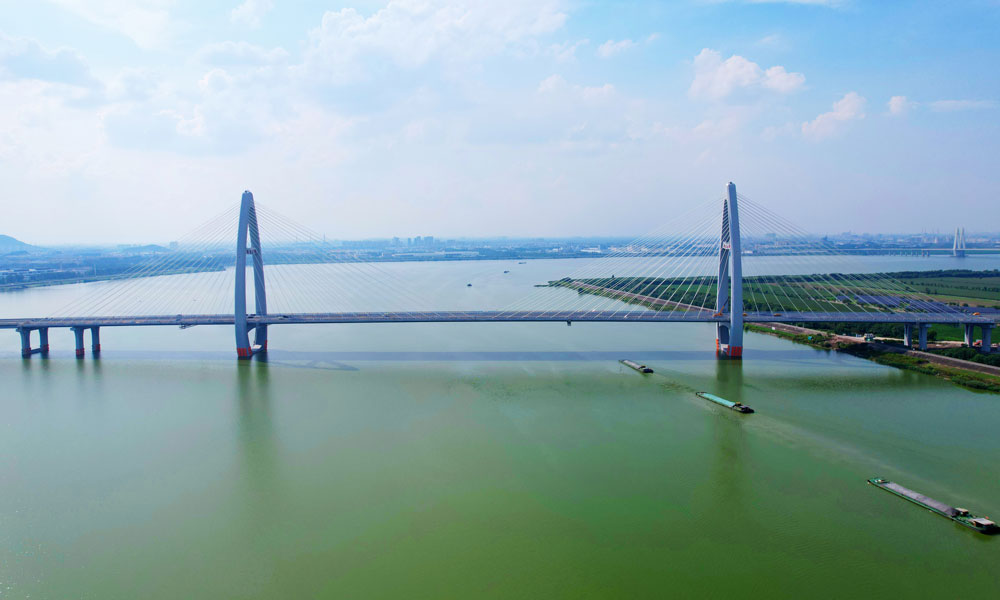 越东大桥是连接线项目的关键控制性工程，是近年来浙江省内实施的在建单体规模最大的斜拉桥工程。大桥主桥长800米，为主跨400米双塔双索面钢混叠合梁斜拉桥。南北两座索塔高约143米，采用全断面小半径多曲率设计，外观为小曲率水滴型，以米粒、鱼儿为设计灵感，融入绍兴“鱼米之乡”的江南水乡情怀，造型优美、结构新颖，兼具实用性和观赏性，成为曹娥江上一道靓丽的风景线。中铁九桥主要承接全桥约1.32万吨钢结构制造安装任务。