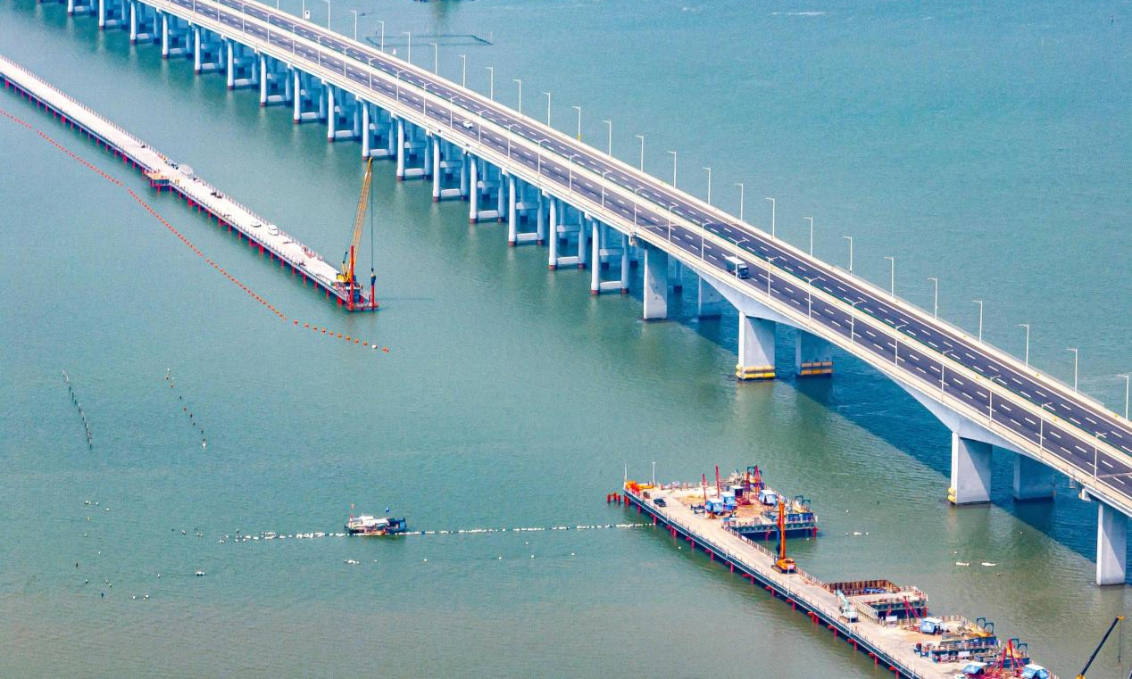 近日，中铁四局新建漳汕高铁漳江湾跨海特大桥主栈桥施工现场机械林立，近百名施工人员全力冲刺栈桥合龙节点目标。漳汕高铁线路全长约175公里，全线涉及3座跨海大桥，其中漳江湾跨海特大桥为全线控制性工程，桥梁全长5.8公里，海域部分桥梁长5公里。为解决海上材料、设备运输和人员通行和主体工程作业要求，四局建设者在漳江湾海域搭设长4.7公里、宽8米的主栈桥。目前，大桥桩基、承台、墩身施工正在有序推进建设。