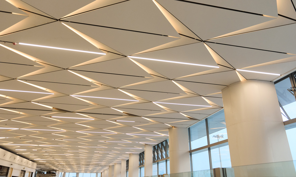 步入航站楼，江南水乡的温婉与灵动扑面而来，接待大厅的菱形网格吊顶以嘉兴水网为灵感，6000块曲面铝板经七道机械拋光，内嵌LED灯带勾勒“水波流转”光影，贵宾厅墙面800余块蚕丝纹石材，运用五轴水刀切割技术，将拼缝控制在1毫米内，远观似绸缎垂落，近触如玉璧生温。