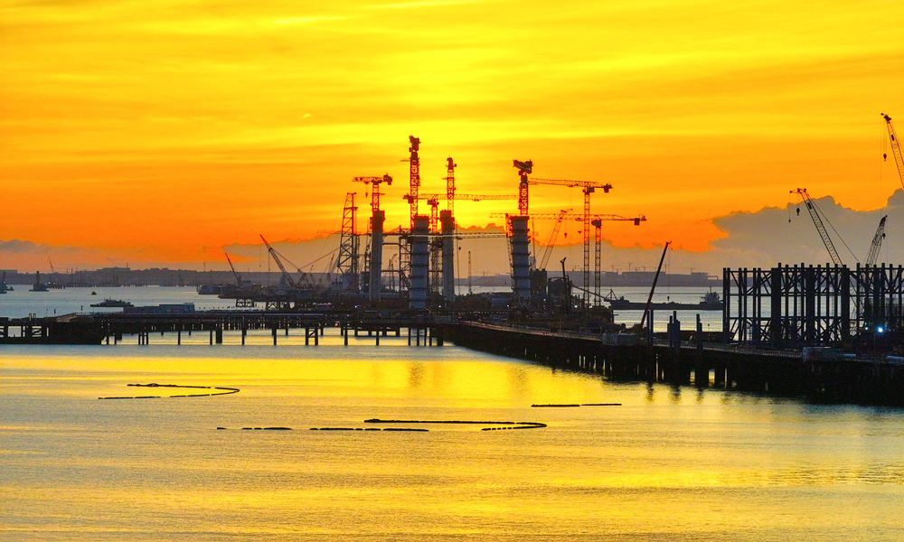 初秋晨曦，橙紫交融。中交二航局参建的厦金大桥（厦门段）项目施工现场披上一身霞光，在云浪翻涌间尽显钢铁长虹磅礴气势。当前，项目取得重要进展，控制性工程刘五店航道桥是福建省首座离岸式海中悬索桥，其西主塔已完成9个节段吊装，西锚碇正稳步推进锚体支架搭设。 