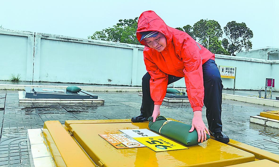 海南石油万宁万州加能站工作人员为油罐区操作井盖增设防风沙袋。