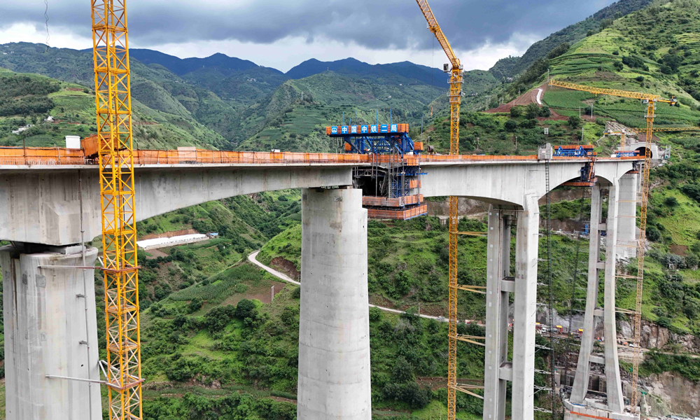 江底牛栏江特大桥横跨云贵交界处的牛栏江V形河谷地带，施工场地狭窄，两岸危岩落石频发。建设过程中，中铁二局项目团队持续改进施工工艺流程等举措，成功攻克了高空作业坠落风险突出等一系列施工难题，为大桥顺利合龙提供了有力支撑。