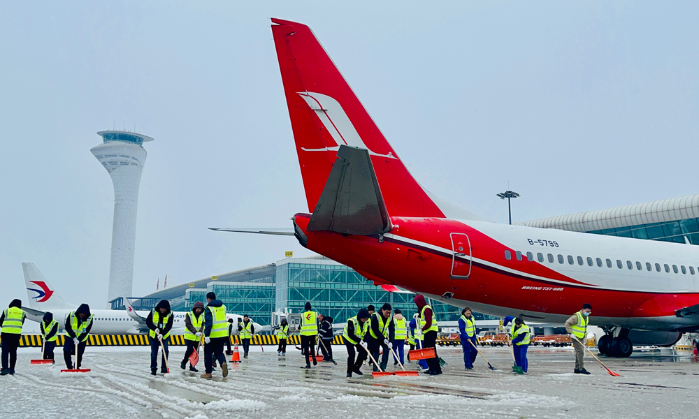 中国东航工作人员及时清理客梯车和通道积雪、对老幼及行动不便旅客主动帮扶。