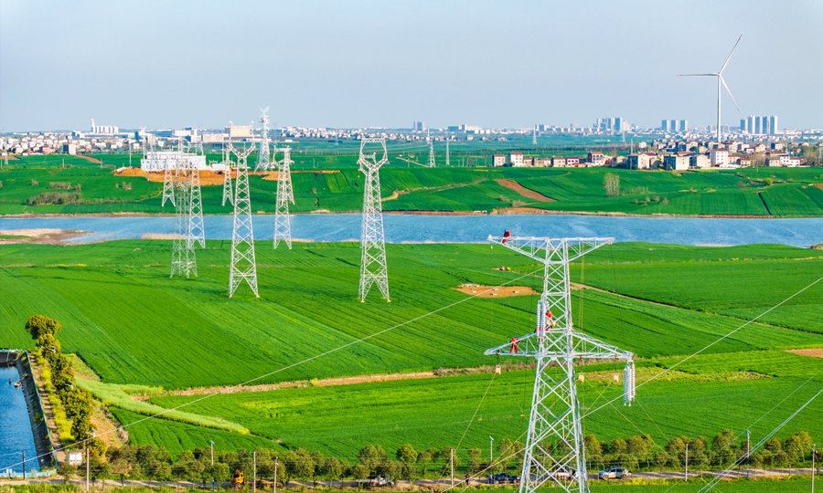 国网湖北襄阳供电公司员工在220千伏楚襄线开展立塔作业，为锂电池新能源项目建成提供电力保障。