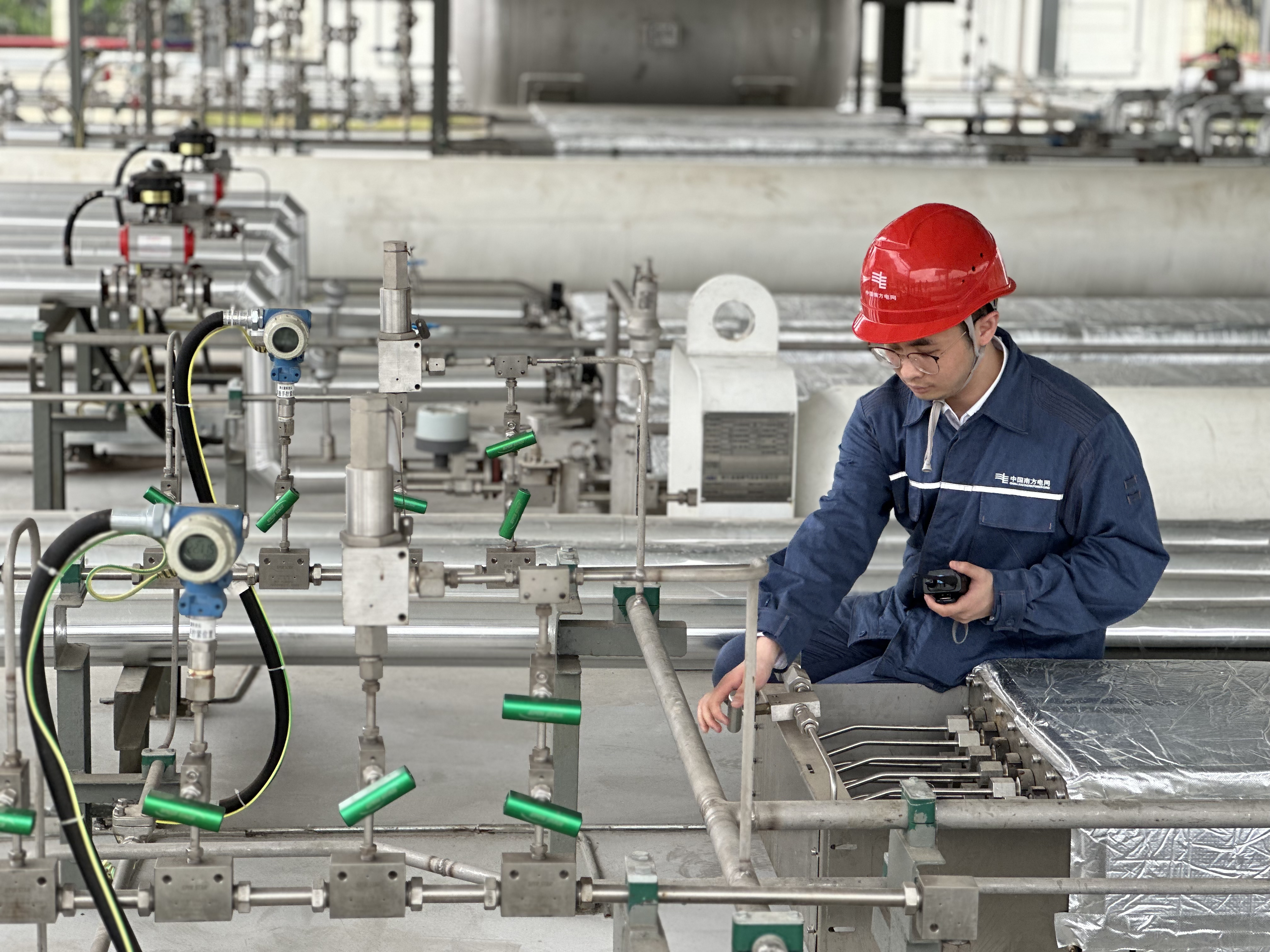南方电网广东广州供电局氢能研究中心工作人员正在检查固态储氢装置气体进出阀门的开闭情况。甘丽莉 摄 (2).jpg