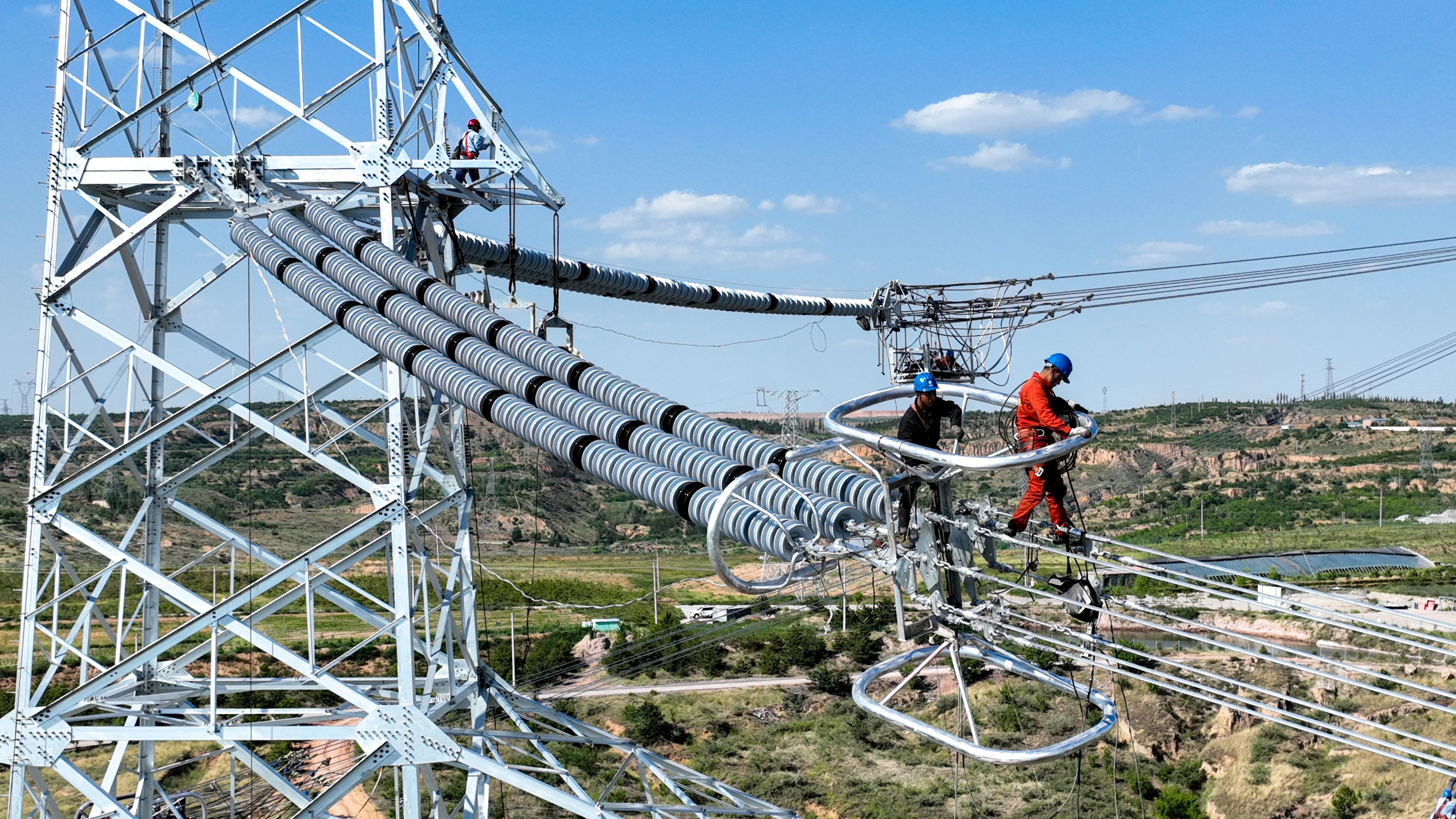6月20日，在内蒙古鄂尔多斯市准格尔旗京泰酸刺沟电厂二期1000千伏送出工程施工现场，国网蒙东电力工作人员在安装均压环。.jpg