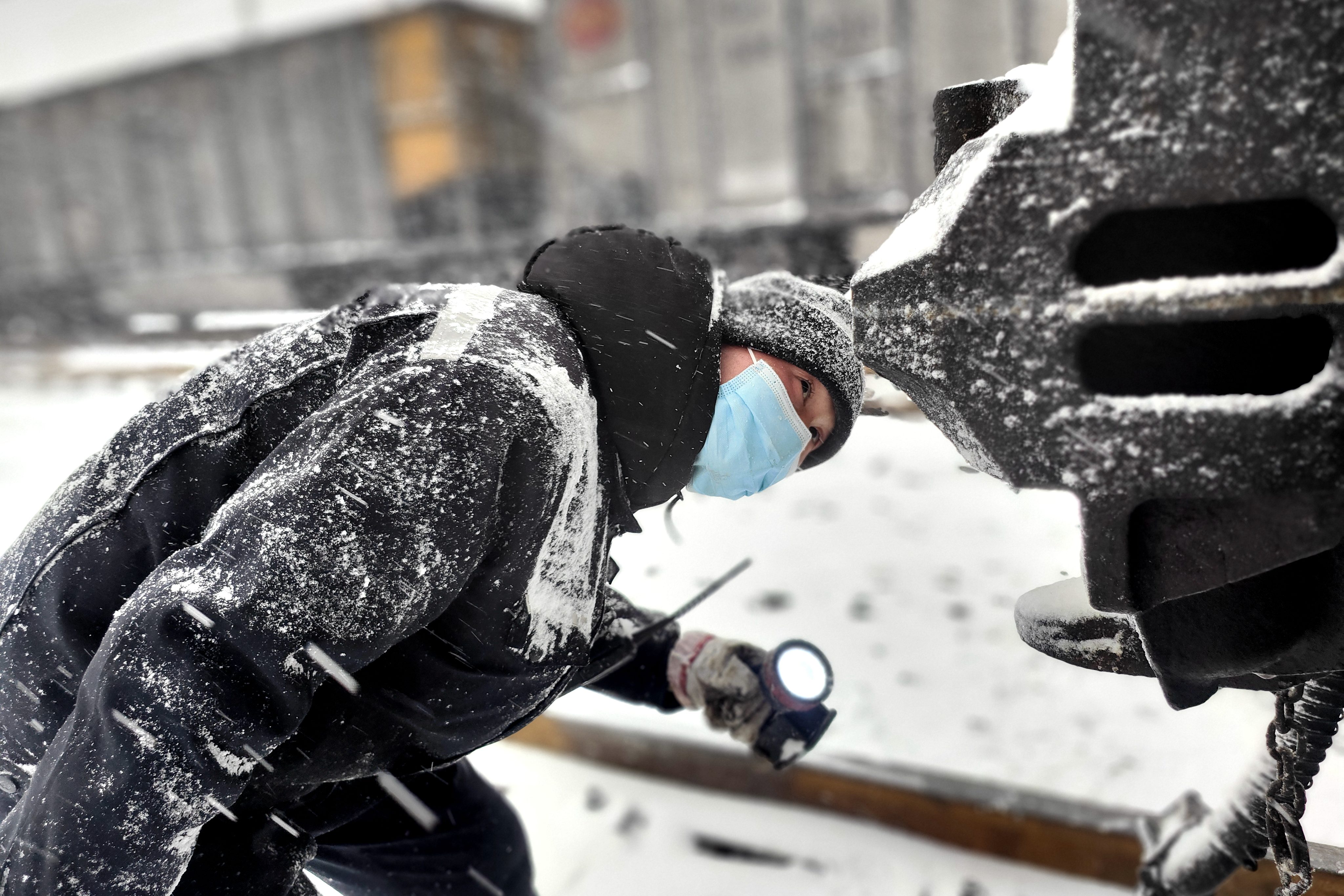 图为1月20日铁路装备肃宁分公司肃宁北列检作业场检车员冒雪对车钩部位进行检查-王建_副本.jpg 图为1月20日铁路装备肃宁分公司肃宁北列检作业场检车员冒雪对车钩部位进行检查-王建_副本.jpg