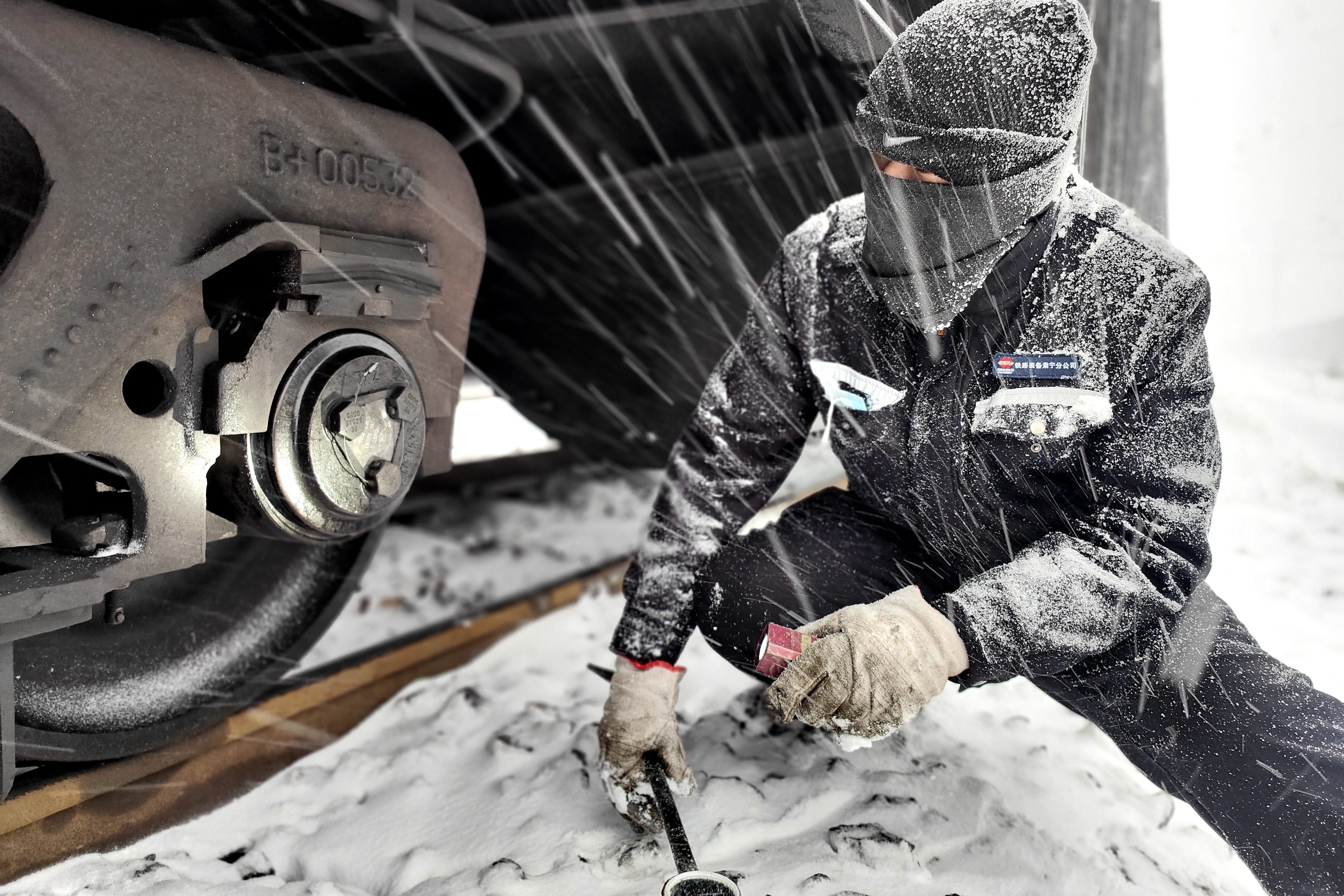 图为1月20日铁路装备肃宁分公司肃宁北列检作业场检车员冒雪对车辆轴承部位进行检查-王建_副本.jpg 图为1月20日铁路装备肃宁分公司肃宁北列检作业场检车员冒雪对车辆轴承部位进行检查-王建_副本.jpg