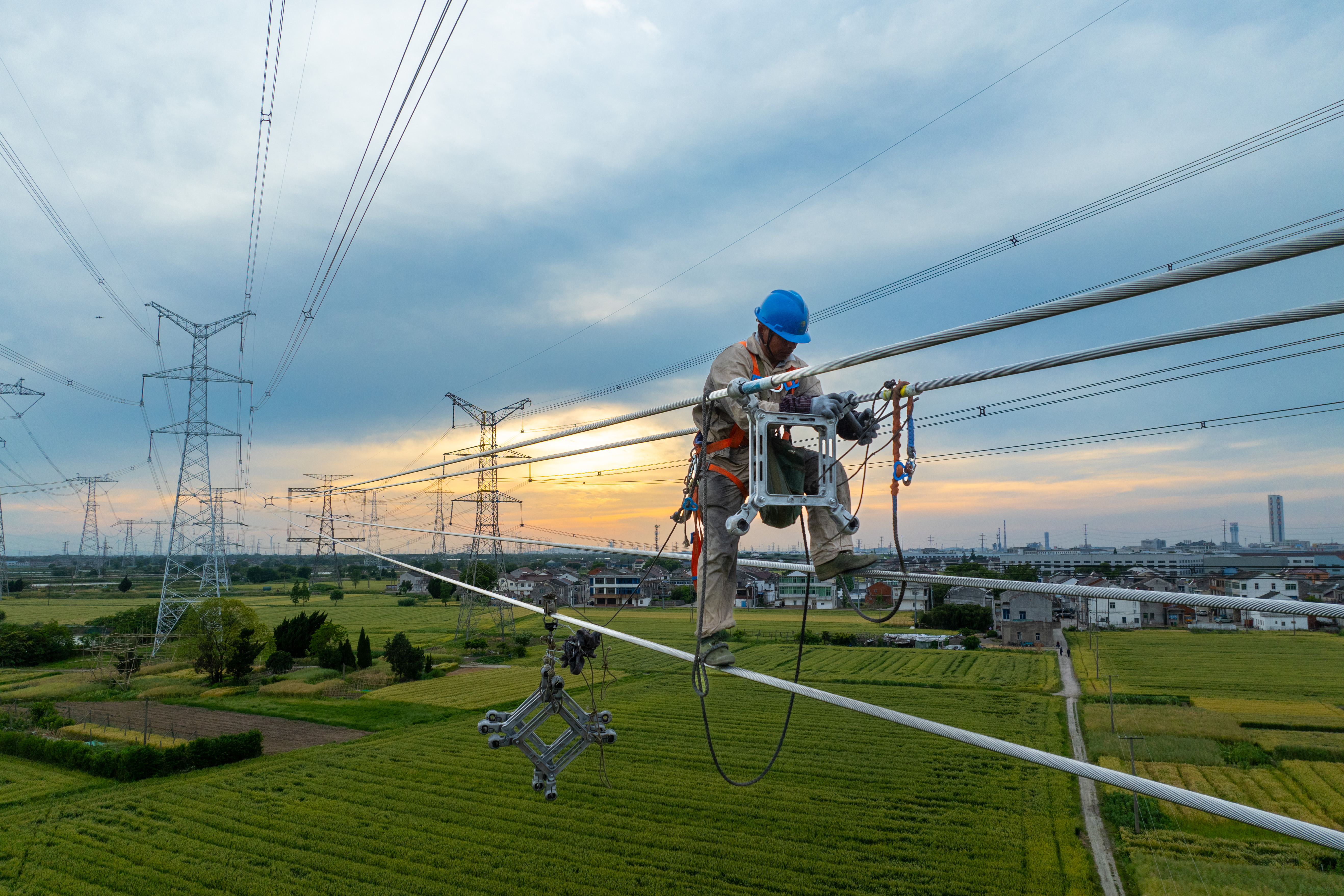 江苏西津渡-廻峰山-武南500千伏线路改造工程无锡宜兴段现场，工作人员正在进行间隔棒安装作业。.jpg