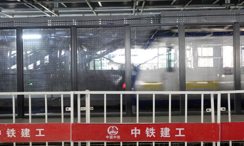 图为2月20日，地铁列车通过建设中的京张高铁清河站。新华社发（冯凯 摄）