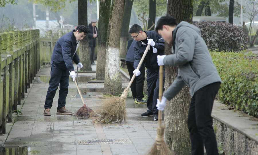 图为中国航发南方公司的青年走进社区，清洁环境。