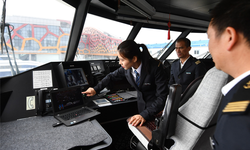 图为3月5日，何倩倩和同事在开航前检查客船设备。（唐蜀全 摄）