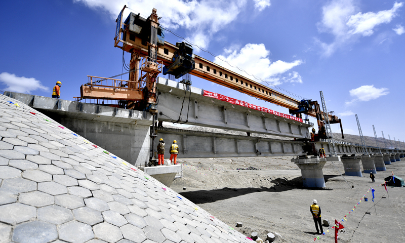 5月7日， 青海格尔木至新疆库尔勒铁路青海段线下主体工程顺利完工。图为5月7日，中铁二十二局集团施工人员在格库铁路茫崖湖2号特大桥上架设T梁。（新华社记者 张龙 摄）