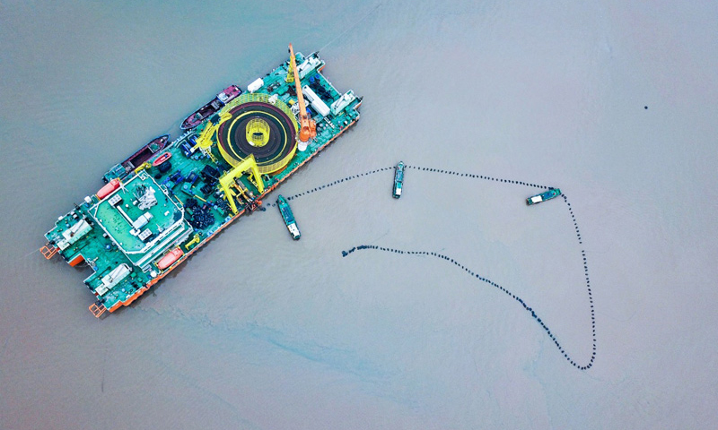 图为6月2日，最后一段海底电缆从海缆施工船上缓缓拖向舟山大鹏山岛。（新华社记者 徐昱 摄）
