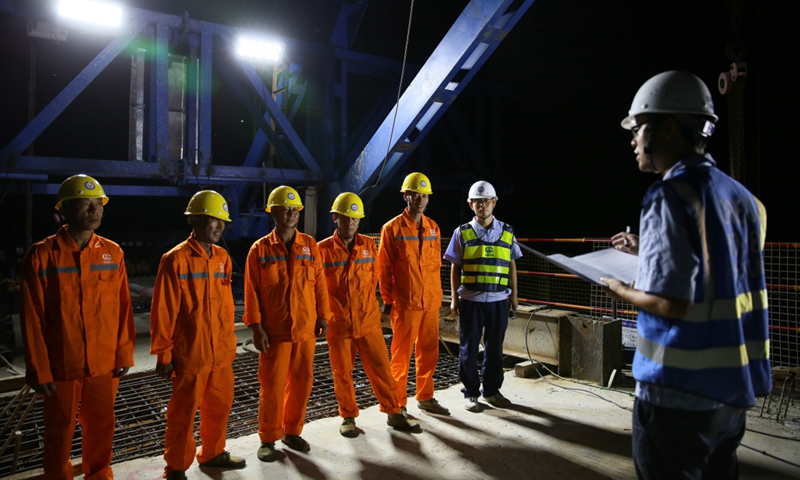 图为7月28日零点，中国中铁八局工人在中老铁路老挝琅勃拉邦湄公河特大桥上接受大桥合龙工作的任务。新华社发（熊天泽 摄） 