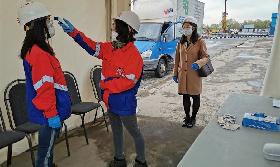 　5月5日，在俄罗斯首都莫斯科，工作人员接受体温检测。 新华社发