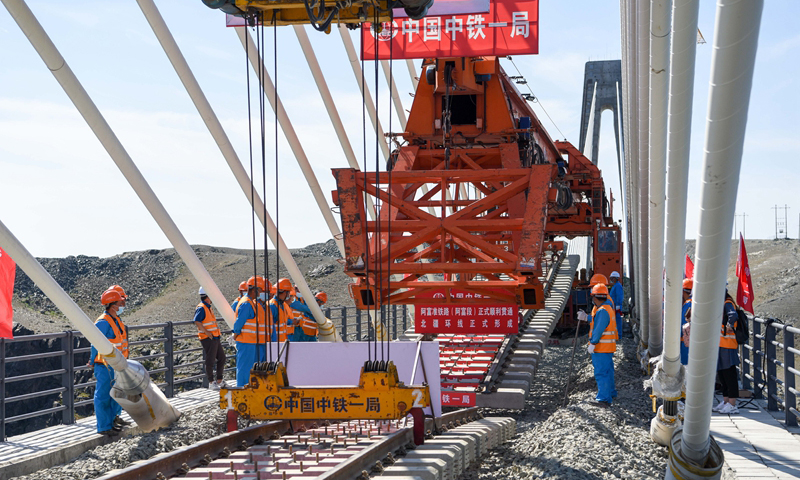 图为7月2日，中铁一局的施工人员在阿富准铁路阿勒泰至富蕴段进行铺轨作业。（新华社记者 丁磊 摄）