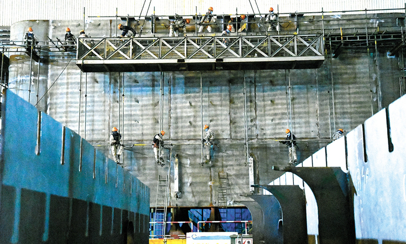 2019年5月，船体建造开工，至2020年6月14日，最后一船（第七船）船体分段顺利卸船交付。历时388天，陵水项目顺利完成82个船体分段建造和交付任务，实现结构封顶重要里程碑。图为今年4月，船体分段建造赶工现场，施工人员正在进行脚手架搭设作业。