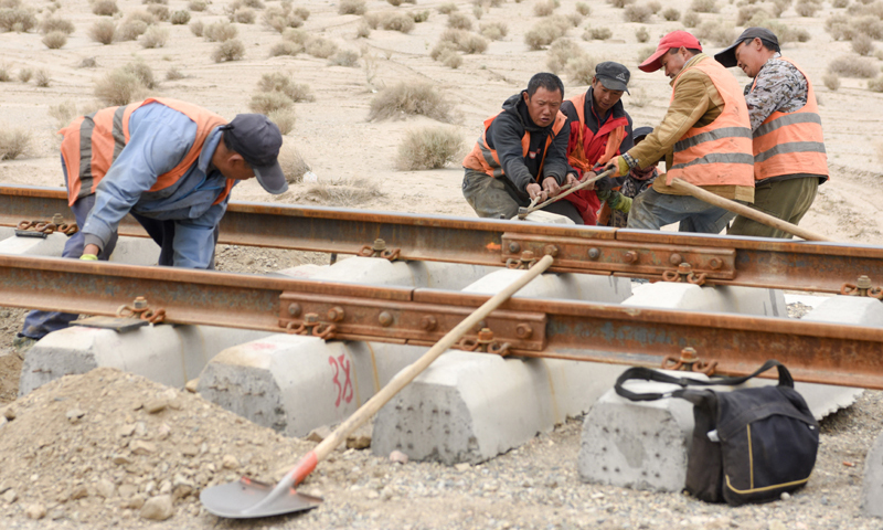 格库铁路新疆段长约708公里，是新疆的第三条出疆通道。图为7月19日，中铁一局的施工人员在抽换电容枕。（新华社记者 丁磊 摄）