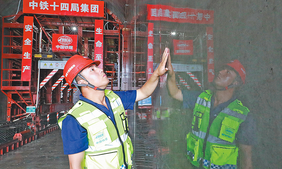 日前，中国铁建所属中铁十四局二公司洛宁抽水蓄能电站项目部浇筑的第一仓清水镜面混凝土揭开了神秘的“面纱”。图为技术人员在查看混凝土养护效果。（王亮亮 摄）