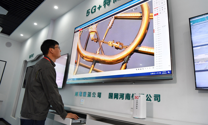 图为8月26日，工作人员利用高清视频监控设备观察检查线路连接件。（新华社记者 李嘉南 摄）