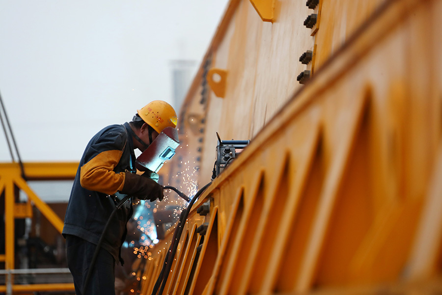 图为工作人员在焊接高铁千吨级运梁车部件。（徐云华 摄）