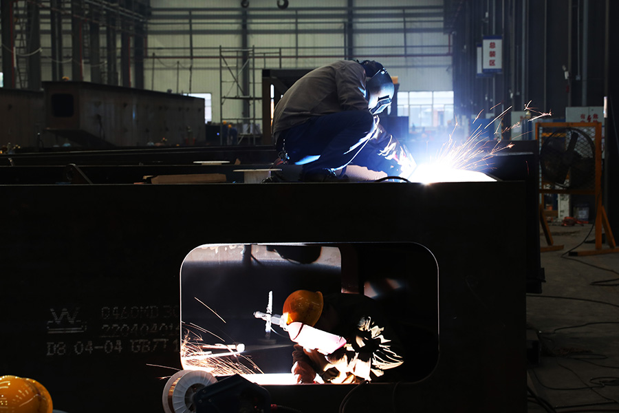 图为工作人员在焊接高铁千吨级运梁车部件。（徐云华 摄）