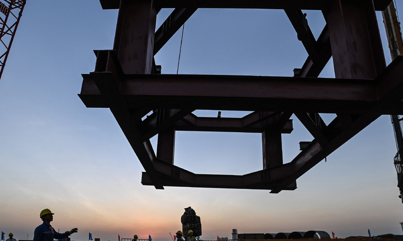 图为10月26日，施工人员在位于广州南沙区的南中高速洪奇门特大桥东塔平台吊装钢护筒导向架。（新华社记者 刘大伟 摄）