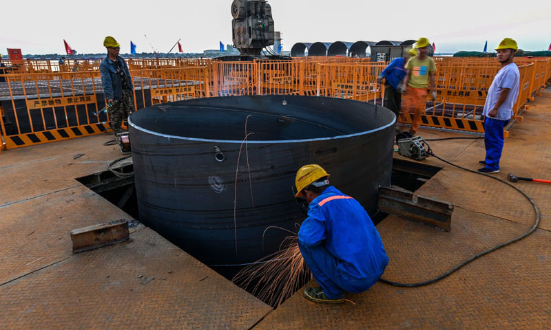 图为10月26日，施工人员在位于广州南沙区的南中高速洪奇门特大桥东塔平台焊接钢护筒。（新华社记者 刘大伟 摄）