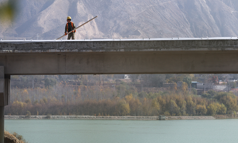 图为11月1日，青海省黄南藏族自治州尖扎县境内的马康公路解放村大桥，一名施工人员正在桥面施工。（新华社记者 吴刚 摄）