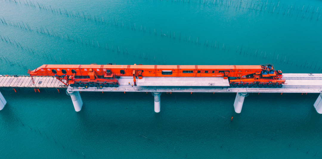 近日，在新建福厦高铁施工现场，由中国铁建研发、设计、制造并施工应用的世界首台千吨级架桥一体机“昆仑号”，开始架设世界首座采用1000吨重、40米跨箱梁的跨海高铁桥梁——新建福厦高铁湄洲湾跨海大桥。这也是继6月22日“昆仑号”正式投用以来，首次在海上强风环境的新工况下，对“大国重器”的再次检验。图为“昆仑号”运送重箱梁前往架设区。
