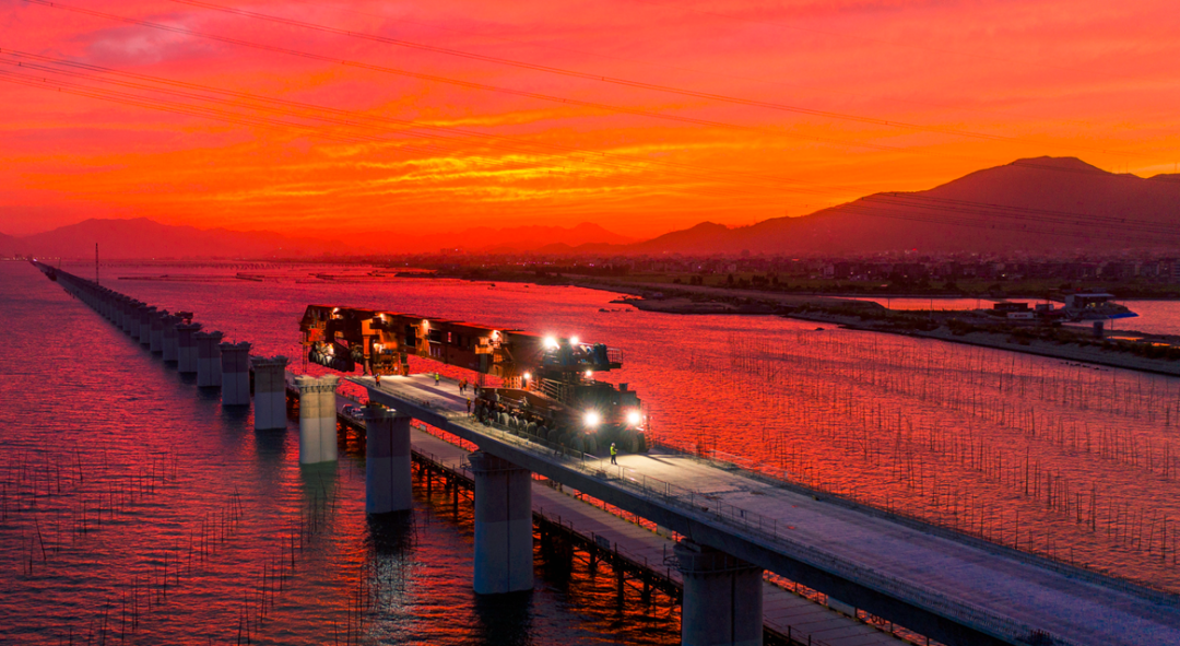 图为海湾夕阳映照在完成架设的“昆仑号”上。