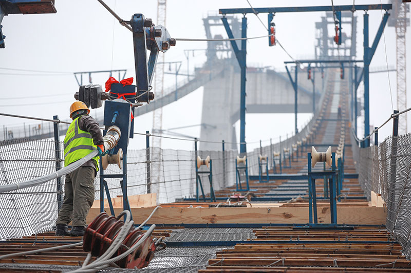 图为1月5日，一名建设者在开州湖特大桥建设工地进行主缆索股架设。（新华社记者 刘续 摄）