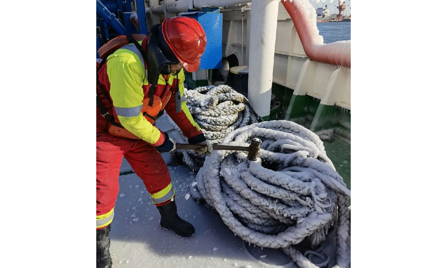 缆绳被冻成“冰棍”，工作人员用榔头一锤一锤把冻冰砸碎。