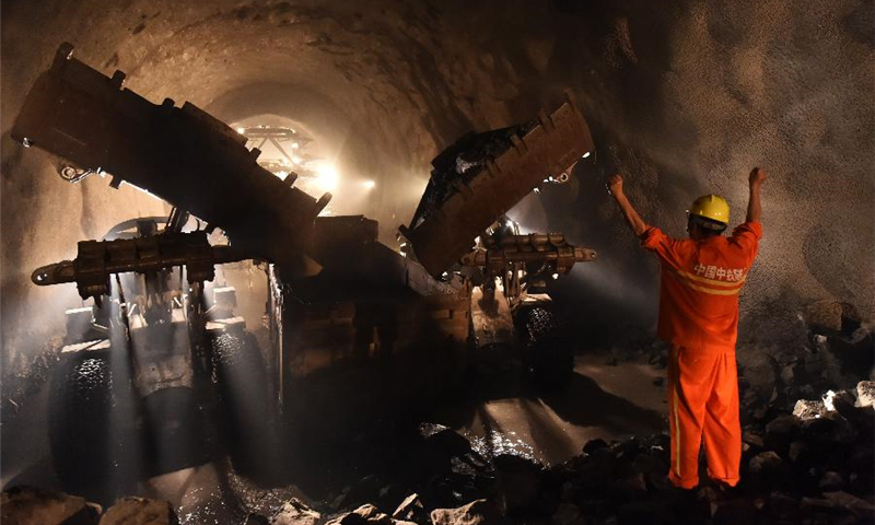 7月16日，工人在隧道贯通点指挥车辆清运石方。（董乃德 摄）
