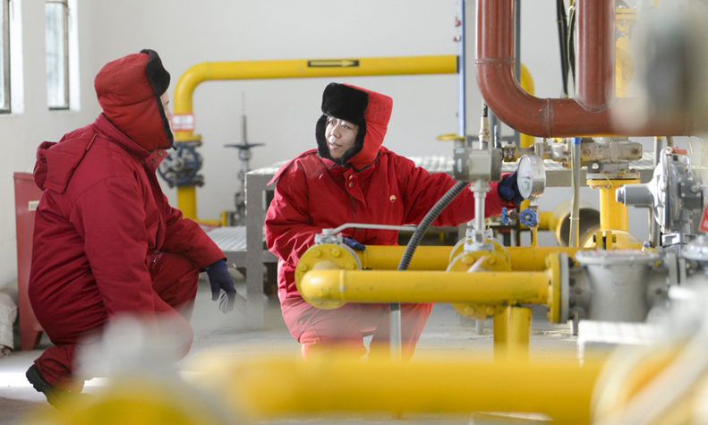 在新疆油田公司油气储运公司总站里，工作人员陈宇（右）和桂勇在对加热炉进行巡检。（新华社记者 赵戈 摄）