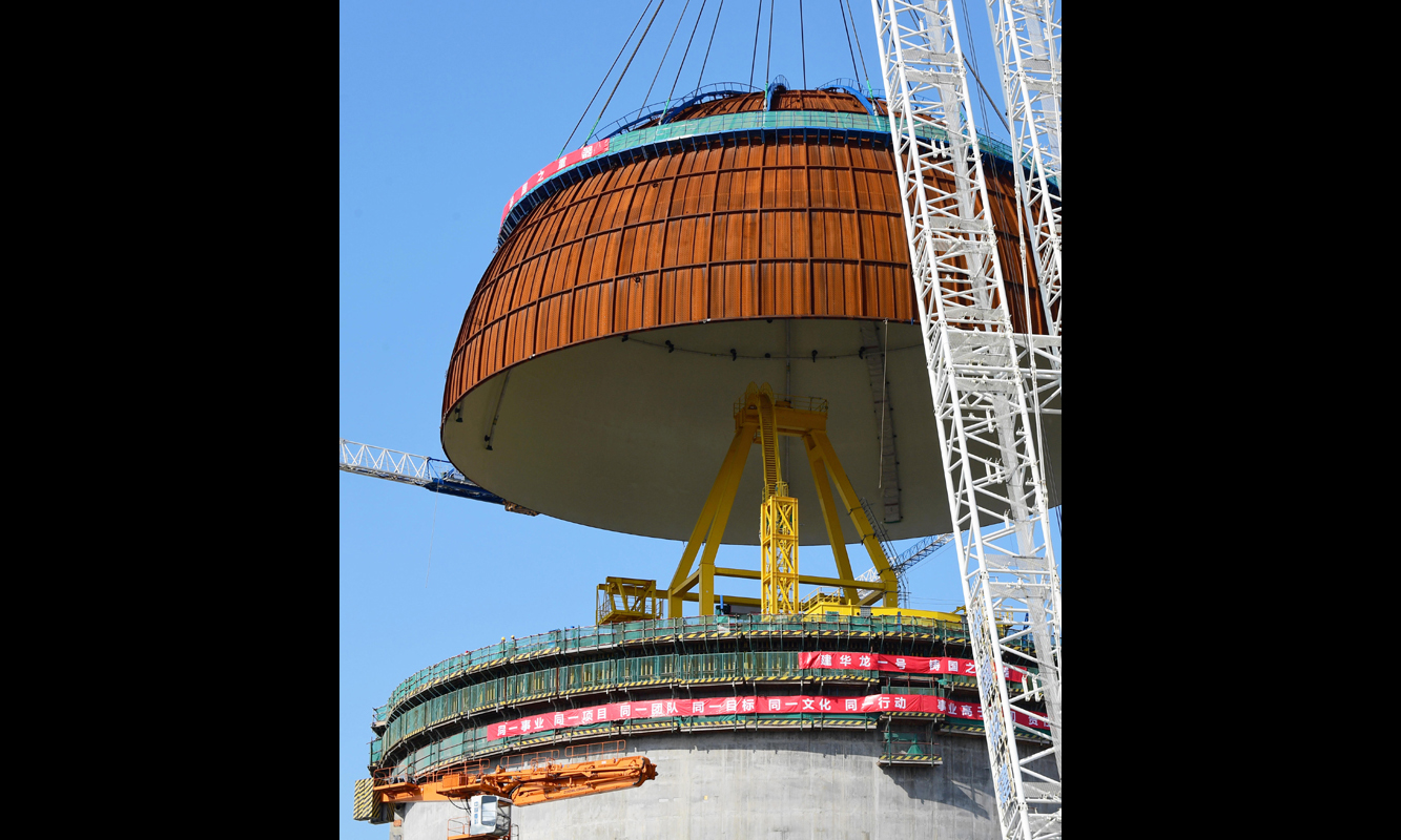 3月21日，由147块约6毫米厚的钢板焊接而成的穹顶正在慢慢吊装到福清核电6号机组反应堆顶上。（新华社记者 魏培全 摄）