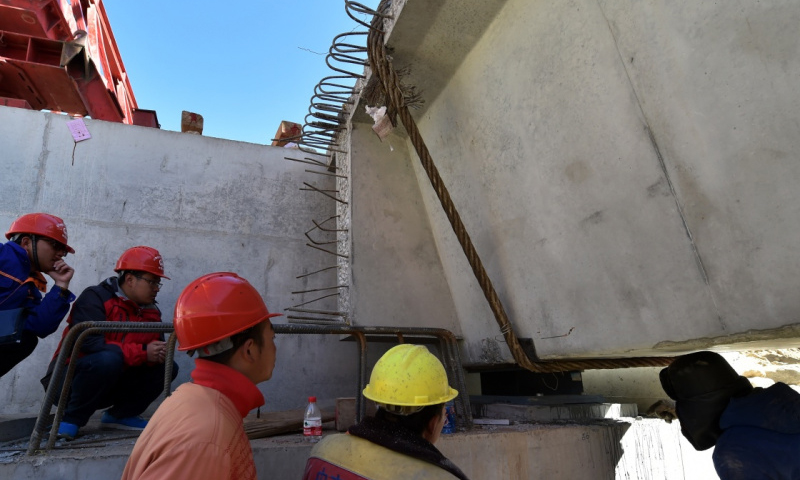 4月22日，工作人员在拉萨至那曲高等级公路昂嘎大桥施工现场检查梁与桥墩的结合部。（新华社记者 觉果 摄）